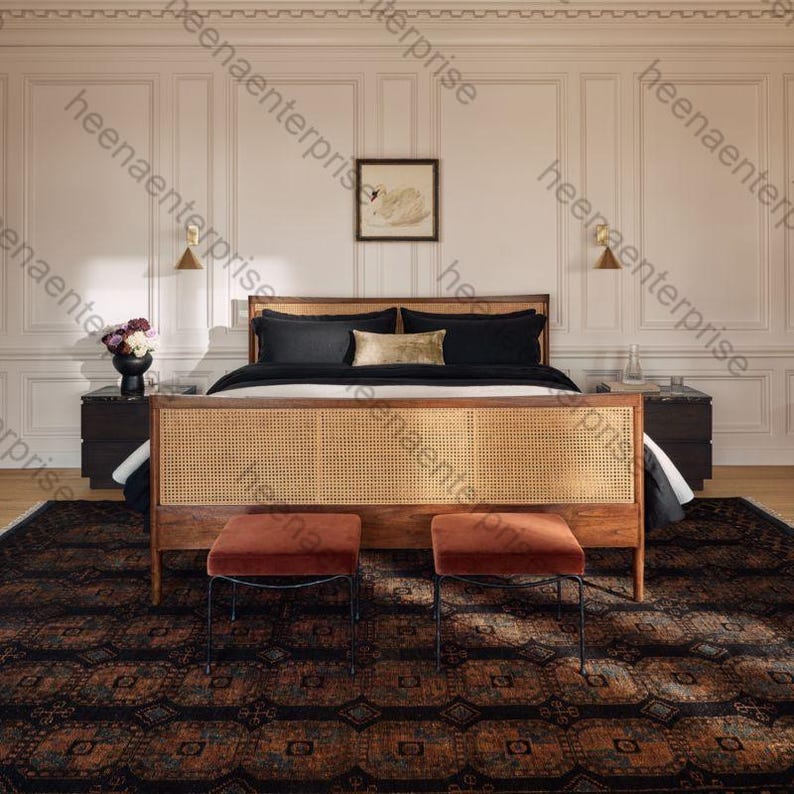 K&ouml;nnte beinhalten: Ein Schlafzimmer mit einem Holzbett mit einem gewebten Kopfteil, schwarzer Bettw&auml;sche und zwei Hockern mit rostfarbenen Samtsitzen. Der Raum hat einen gemusterten Teppich und ist mit Wandkunst und Wandleuchten dekoriert.