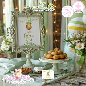 May include: A St. Patrick's Day display with a framed sign saying "Baked Potato Bar." The sign features a potato character in a leprechaun hat. There's a cake stand with baked potatoes, and small bowls of toppings, all on a green tablecloth.