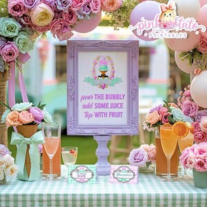 May include: A lilac framed sign with text that reads "pour the bubbly, add some juice, top with fruit." The sign is surrounded by floral arrangements, balloons, and drinks. Two small signs read "Orange Juice" and "Strawberries."