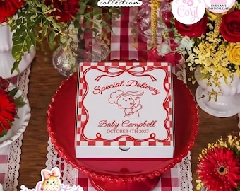 May include: A white square pizza box with a red checkered border and red text that reads Special Delivery, Baby Campbell, and OCTOBER 4TH 2027, featuring a graphic of a baby chef tossing dough, centered on a red scalloped cake stand.