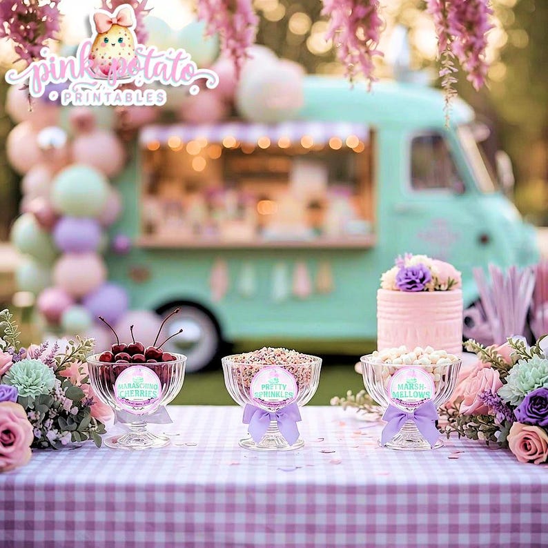 May include: A festive outdoor scene with a pastel-colored dessert table. Clear glass bowls hold cherries, sprinkles, and marshmallows, each labeled with a decorative tag and tied with a purple ribbon. A pink cake and a teal food truck are in the background.