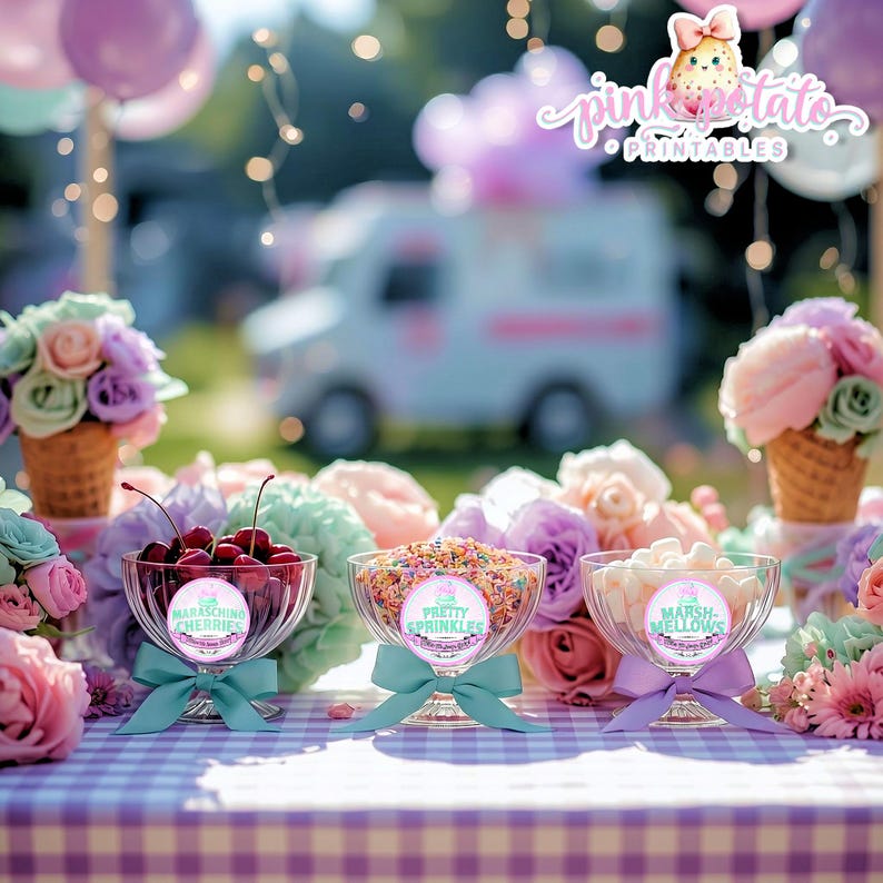 May include: A festive outdoor dessert display featuring three glass bowls filled with maraschino cherries, colorful sprinkles, and marshmallows. Each bowl has a teal or purple bow. The scene includes floral arrangements, balloons, and an ice cream truck in the background.