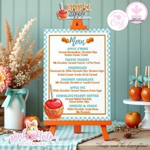 May include: A rectangular menu sign with a blue and white gingham border on an orange easel. The text lists caramel apple flavors including Apple S'more, Toffee Peanut, Cheesecake, Coconut Chocolate, Apple Pie, Chocolate Peanut Butter, and Cookies & Cream.