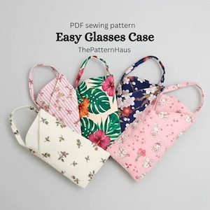Puede incluir: Varios estuches de gafas de tela con diversos diseños florales y estampados. Los estuches, en tonos rosa, blanco, verde y azul, tienen un asa. El texto en la imagen dice "Easy Glasses Case".