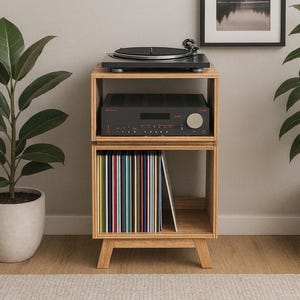 May include: A wooden audio cabinet with a black turntable, amplifier, and a collection of vinyl records. A framed landscape art piece hangs on the wall. The cabinet is made of light-colored wood and has a minimalist design.