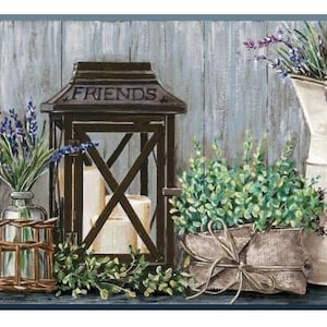 May include: A rustic still life featuring a dark brown lantern with the word "FRIENDS" on top, flanked by glass vases with lavender and a white pitcher with lavender. A burlap-wrapped plant and candles complete the scene.