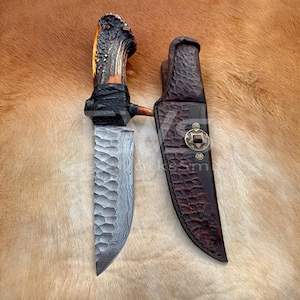 Cuchillo Bowie de acero de Damasco forjado a mano, mango de asta de ciervo, hoja texturizada y funda de cuero hecha a medida.