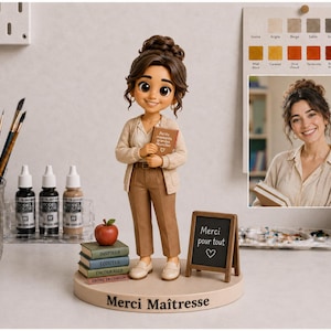 May include: A custom figurine of a person with brown hair in a bun, wearing a beige cardigan and brown trousers. The figure holds a book and stands on a round base labeled "Merci Ma&icirc;tresse" with a stack of books, an apple, and a small chalkboard.