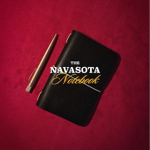 May include: A black leather notebook with a white elastic band closure and a metallic pen. The cover features the text THE NAVASOTA Notebook in white and yellow font. At the bottom, the text reads YELLOW ROSE HANDMADE in white.