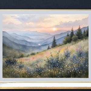 May include: A framed watercolor painting of a mountain landscape at sunset. The artwork features layers of blue-toned mountains, a grassy hillside with wildflowers, and a warm, golden sky. The frame is gold.