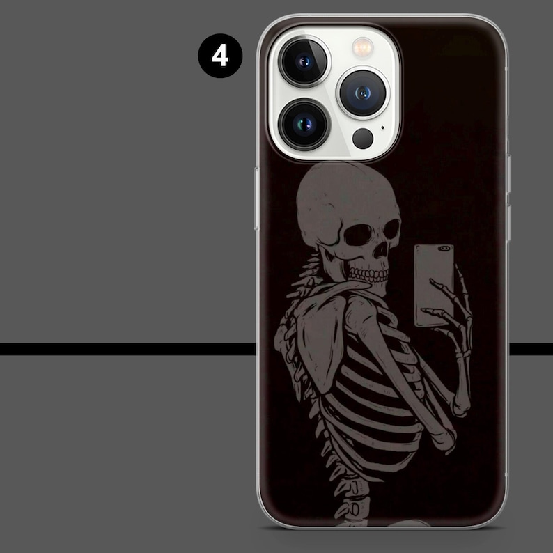 May include: A black phone case featuring a gray skeleton taking a selfie with a smartphone. The skeleton is depicted in a detailed, artistic style, with visible ribs and skull. The case has a clear border and a dark background.
