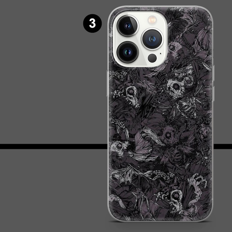 May include: A phone case with a dark, detailed pattern of skulls and skeletal figures. The case is clear, allowing the phone's design to be partially visible. The number "3" is in a white circle in the upper left corner.