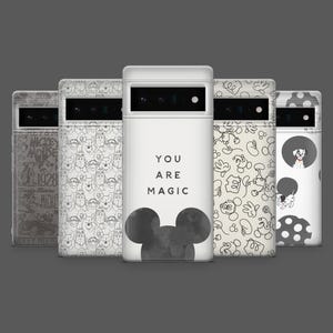 May include: A collection of white phone cases with various designs. One case features the text "YOU ARE MAGIC" with a Mickey Mouse silhouette. Other cases display Mickey Mouse, Dalmatian, and vintage Mickey Mouse graphics.