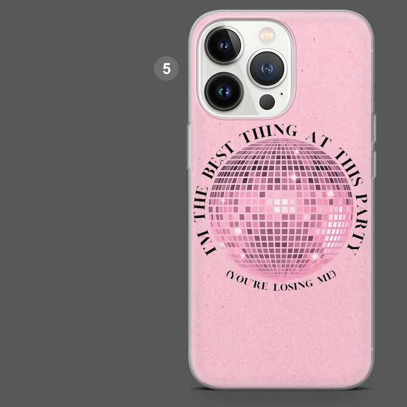 Puede incluir: Funda de tel&eacute;fono rosa con un dise&ntilde;o de bola de discoteca y el texto "I'M THE BEST THING AT THIS PARTY (YOU'RE LOSING ME)". La funda tiene un acabado brillante y un recorte para la c&aacute;mara.