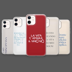 Op de afbeelding: Een verzameling iPhone-hoesjes met Italiaanse zinnen. Eén hoesje is rood met witte tekst: "LA VITA E' AMARA, IL VINO NO." Andere hoesjes hebben zinnen in blauw en wit. De hoesjes zijn transparant met een gekleurde achtergrond.