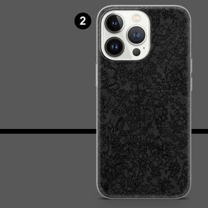 May include: A black phone case with a floral lace pattern. The case has a clear border and a camera cutout. The phone case is designed to fit a smartphone.
