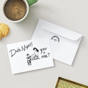 May include: A white greeting card with the words "Date Night! you + me?" and a black and white illustration of a couple. A white envelope is next to the card, along with a cup of coffee and two cookies.