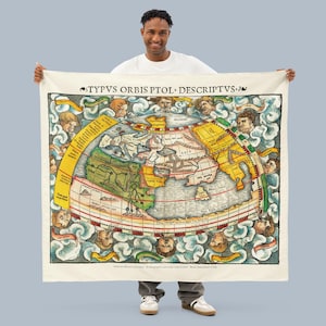 May include: A cream-colored throw blanket featuring a vintage world map illustration. The map, in shades of yellow, green, and blue, is surrounded by decorative figures and text. The blanket has the text "TYPVS ORBIS PTOL. DESCRIPTVS." at the top.