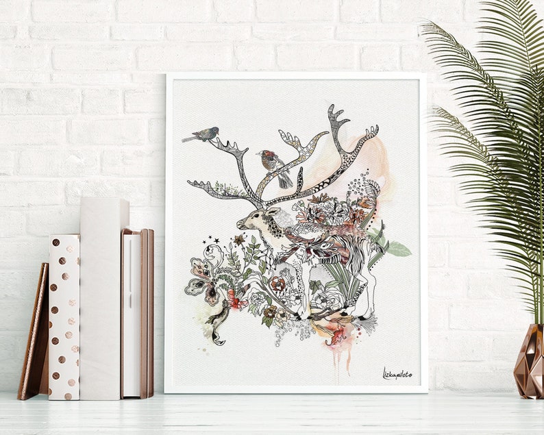 White framed wall art featuring a detailed ink drawing of a deer's antlers intertwined with floral elements and small birds. The artwork is in shades of black, gray, and muted pinks and oranges on a light beige background. The artist's signature is visible in the bottom right corner. The style is reminiscent of botanical illustrations and nature-inspired art. The overall aesthetic is elegant and whimsical.