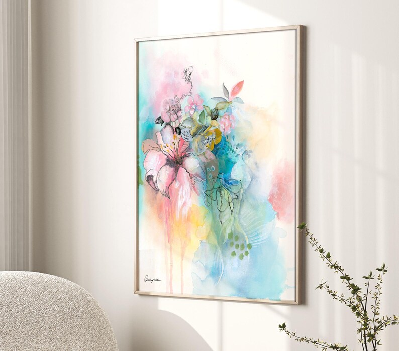 A framed watercolor painting of a bouquet of flowers in shades of pink, blue, green, and yellow. The flowers are painted in a loose, abstract style, and the background is a soft wash of color.
