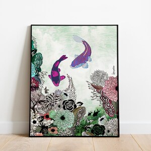 A framed print of a colorful illustration of two koi fish swimming in a pond with a floral background. The fish are purple, pink, and black. The flowers are pink, green, and blue. The background is a light green watercolor wash.