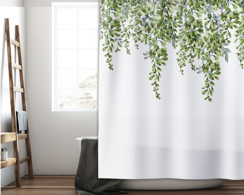 May include: White shower curtain with a green watercolor floral design of leafy vines hanging down from the top. The design is on a white background.