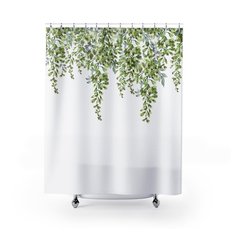 May include: White shower curtain with a green leafy pattern. The leaves are hanging down from the top of the curtain.
