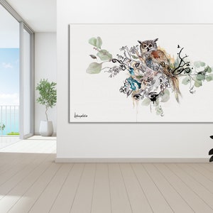 Puede incluir: Una pintura de acuarela de un b&uacute;ho posado en una rama con hojas verdes y un fondo azul claro. El b&uacute;ho es marr&oacute;n y blanco con ojos amarillos. La pintura est&aacute; firmada "Lechwaldo" en la esquina inferior izquierda.