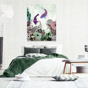 A green, white, and pink floral print with two purple and pink fish swimming in the water. The print is framed and hanging on a white wall above a white bed with green bedding. The bed has two pillows, one green and one white with a black and white geometric pattern. A wooden bench with a gray cushion is in the foreground.