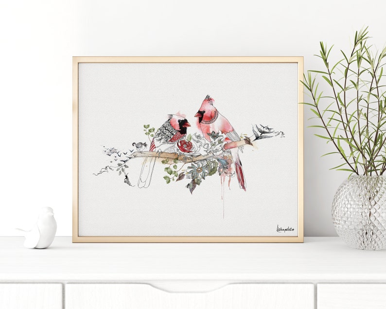 A watercolor painting of two red cardinals perched on a branch with a pink rose. The birds are facing each other and the background is white.