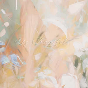 Abstract painting with a soft, muted color palette. The painting features shades of peach, green, white, and yellow. The artist's signature, 'Liz Kapiloto', is visible in the center of the painting.