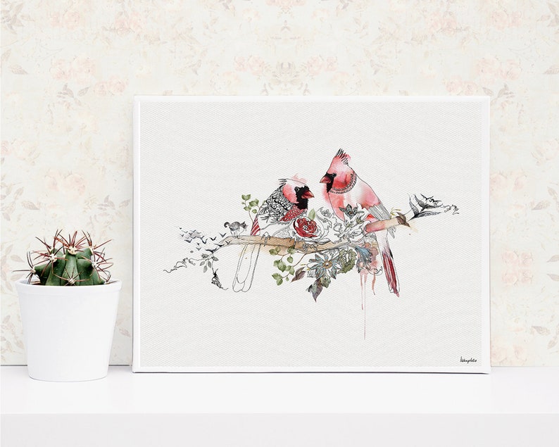 watercolor painting of two red cardinals perched on a branch with delicate flowers and leaves. The birds are facing each other, with the female cardinal on the left and the male cardinal on the right. The painting has a soft, romantic feel.