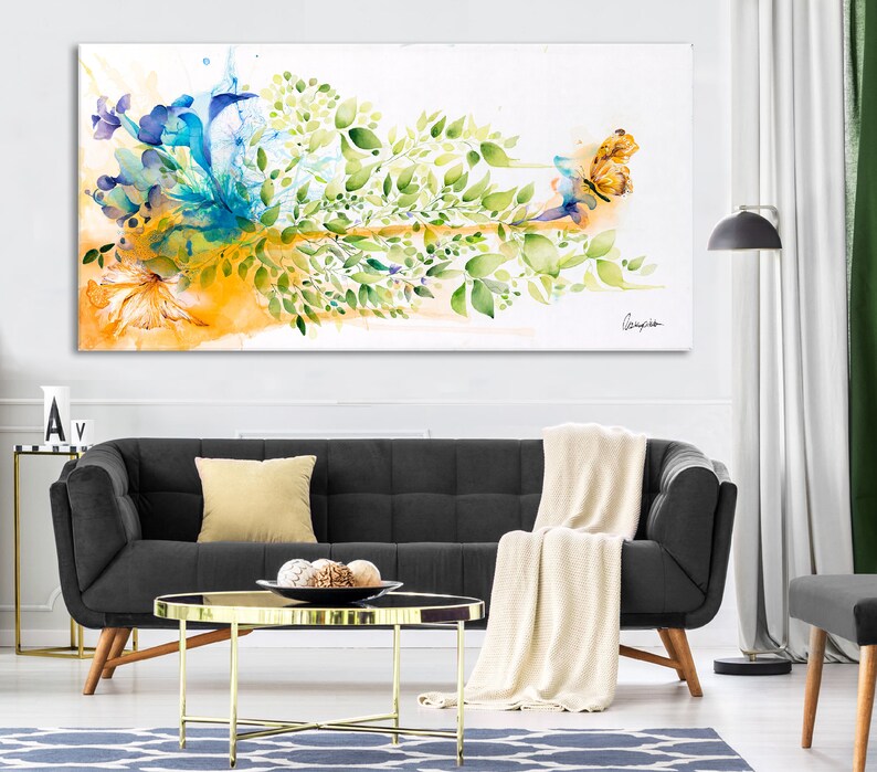 Abstract watercolor painting of a butterfly with blue, green, and yellow colors. The butterfly is surrounded by leaves and flowers.
