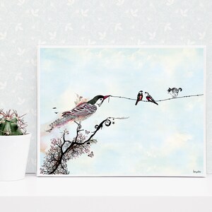 A framed watercolor painting of a bird perched on a branch with a cat and two birds on a wire in the background. The painting is on a white background with a light blue sky. The bird on the branch is detailed with intricate patterns and colors. The cat is black and white and the birds on the wire are red and black. The painting is signed in the bottom right corner.