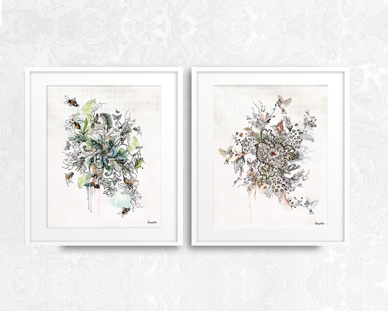 Two framed prints with intricate black and white drawings of floral arrangements with birds and bees. The prints have a watercolor background with shades of blue, green, and pink.
