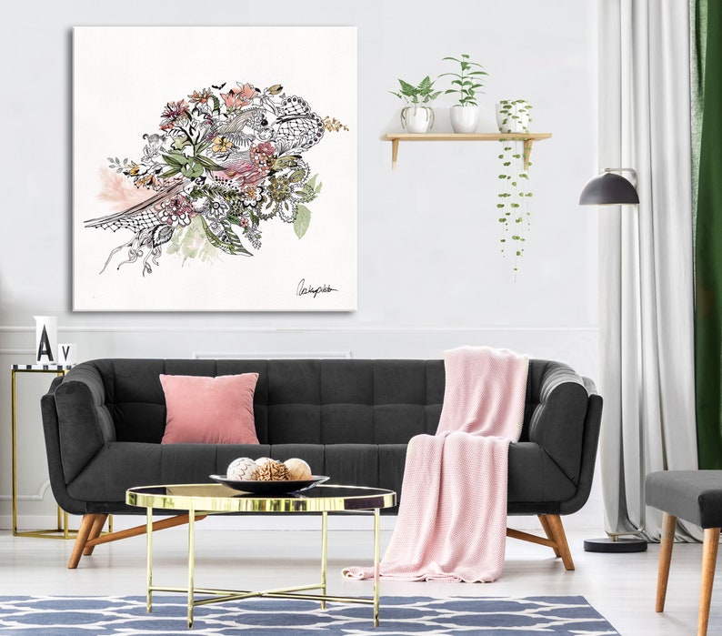 May include: A black sofa with a pink throw blanket and a gold coffee table in a living room setting. A framed black and white floral illustration hangs on the wall above the sofa.