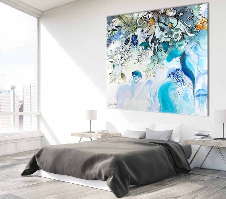 Abstract watercolor painting featuring a blue, green, and white color scheme. The painting depicts a cluster of jellyfish and floral elements. The painting is displayed on a wall above a gray bed with white bedding.