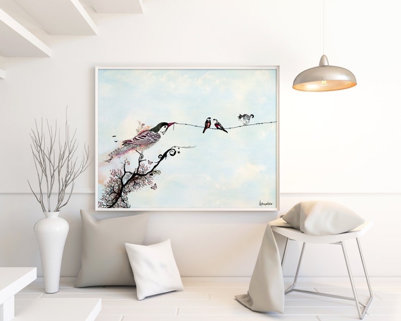 A framed watercolor painting of a bird perched on a branch with two other birds on a wire. The painting is set against a light blue sky with white clouds. The painting is framed in a white frame and is hanging on a white wall.