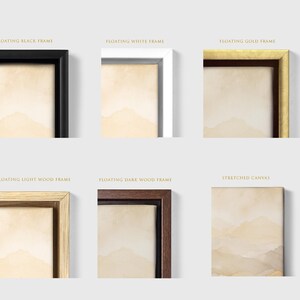 Puede incluir: Una colecci&oacute;n de seis opciones de enmarcado que incluyen un marco flotante negro, blanco, dorado, de madera clara, de madera oscura y un lienzo estirado, todos mostrando un paisaje de monta&ntilde;a en acuarela de color beige.
