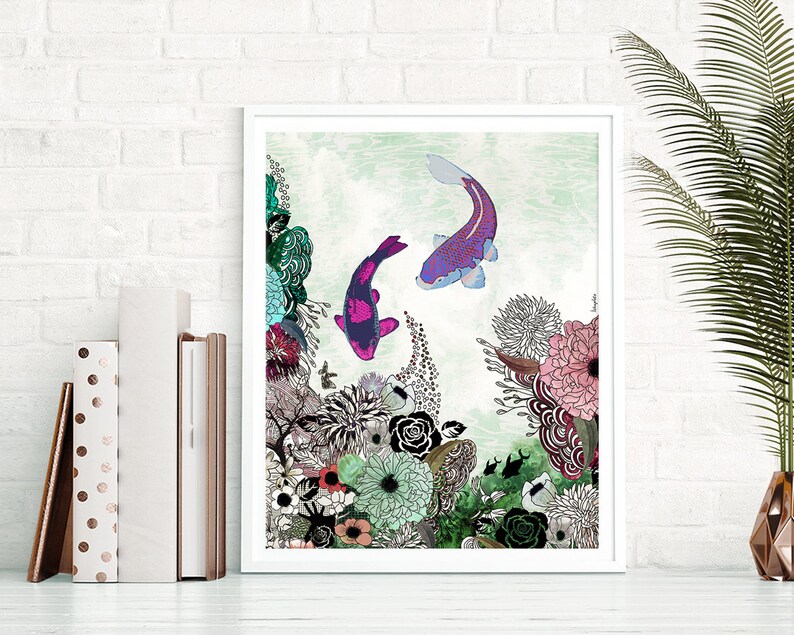 A framed print of a colorful illustration featuring two koi fish swimming in a pond surrounded by flowers and plants. The fish are pink, purple, and black, and the flowers are pink, white, and green. The background is a light green watercolor wash.