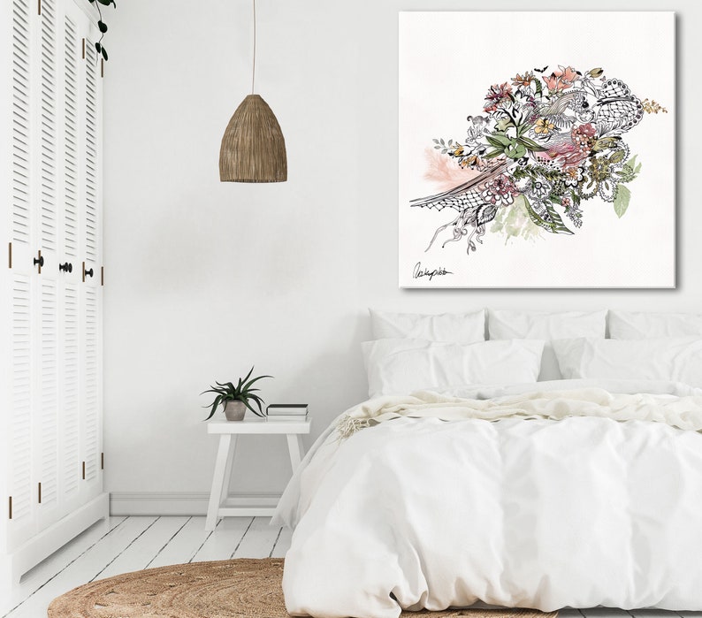 May include: A white canvas print with a black and white floral design with pink and green accents. The design features a variety of flowers, leaves, and branches. The print is framed in a white frame and is hanging on a white wall.