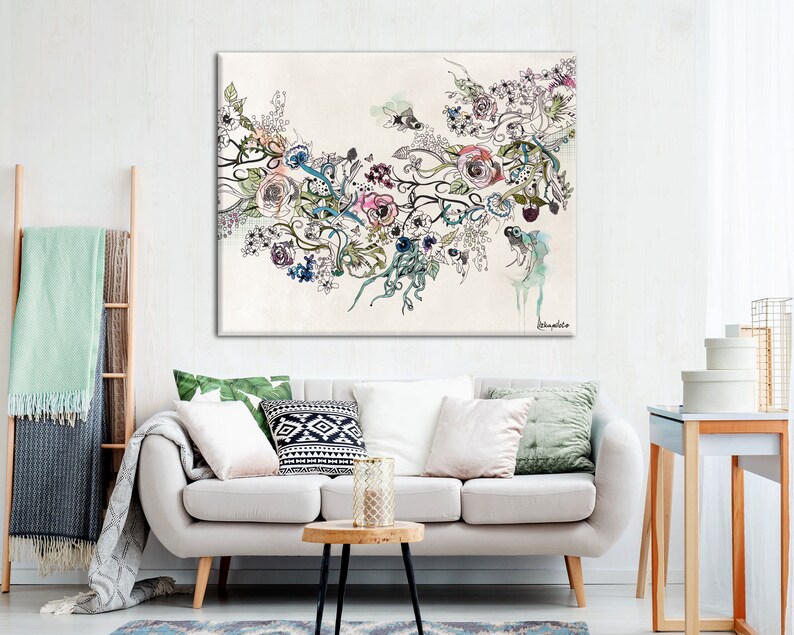 May include: A large canvas art print featuring a floral design with roses, leaves, and abstract elements in shades of pink, blue, and green. The artwork is set against a cream-colored background, creating a soft and elegant aesthetic. The print is displayed in a living room setting.