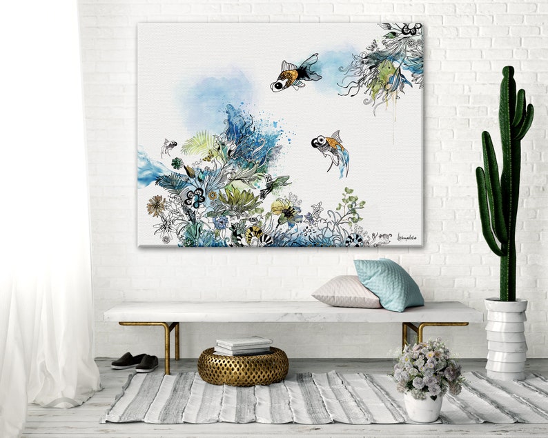 watercolor painting of a white background with blue, green, and yellow floral designs and two gold fish. The painting is framed and hanging on a white brick wall.