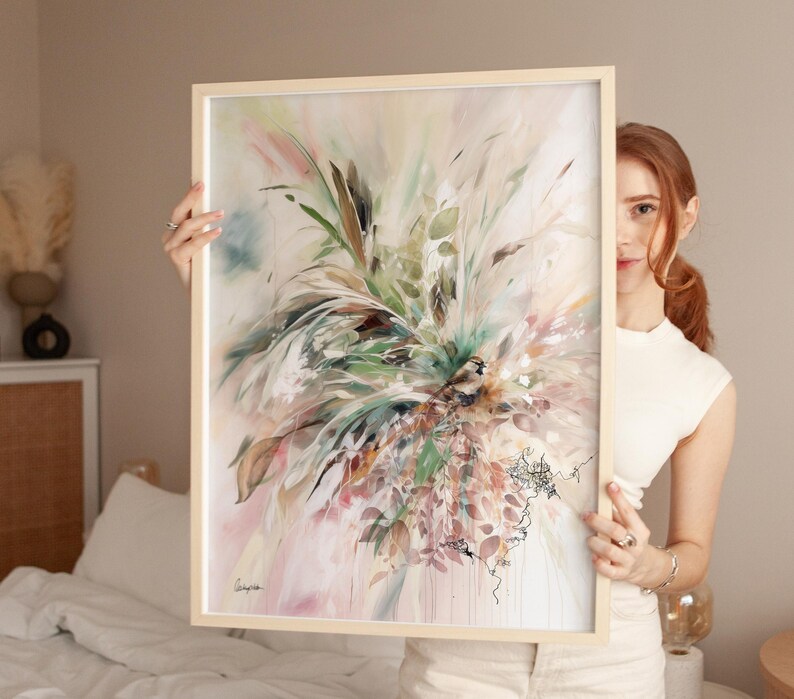 Abstract art print in a light wooden frame. The artwork features a vibrant mix of colors, including green, pink, and beige, with a focus on botanical elements. The painting has a soft, watercolor-like quality, with delicate lines and textures.