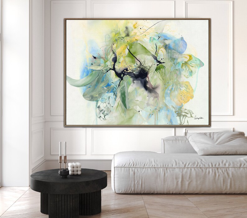 Abstract watercolor painting with shades of blue, green, and yellow. The painting features a large, central flower-like shape with delicate brushstrokes and a black splatter effect.
