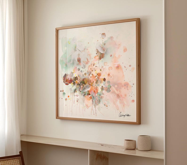 A framed watercolor painting featuring a floral design in soft pastel colors. The artwork includes shades of pink, green, and orange, with a wooden frame. The painting is mounted on a white wall.