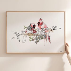 A framed horizontal art print featuring two red cardinal birds perched on a branch. The illustration combines watercolor washes in shades of red and pink with intricate black ink line work, depicting floral elements and foliage.