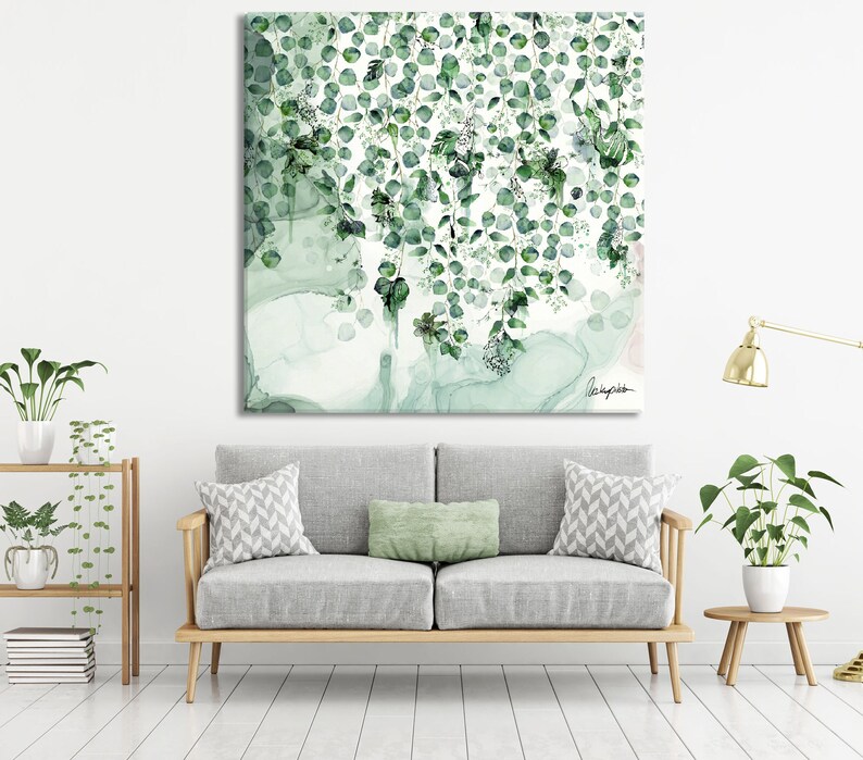 A watercolor painting of green leaves hanging down in a cascade. The background is a light green and white with a faint pink hue. The painting is signed in the bottom right corner.