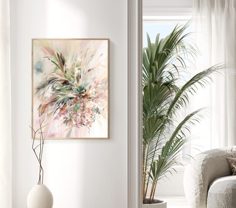 Abstract floral art print in a wooden frame. The artwork features a soft color palette of pink, green, and beige, with brushstrokes creating a dynamic, textured composition. The painting is displayed on a white wall.