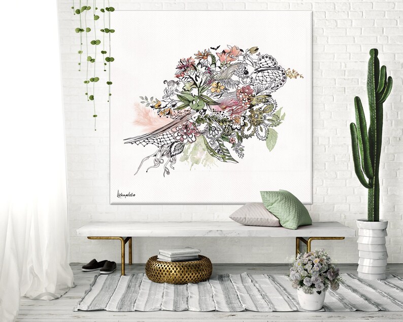 May include: A white canvas print with a black and white floral design. The design features a bouquet of flowers with pink, green, and yellow accents. The print is hanging on a white brick wall above a white bench with a gold metal frame.